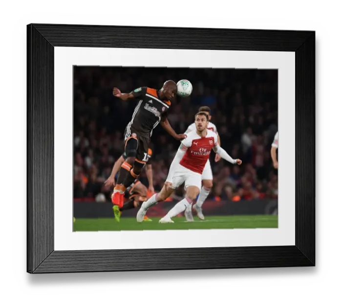 Framed Print : Arsenal's Aaron Ramsey Clashes with Brentford's Kamohelo Mokotjo in Carabao Cup Showdown Framed Print : Arsenal's Aaron Ramsey Clashes with Brentford's Kamohelo Mokotjo in Carabao Cup Showdown