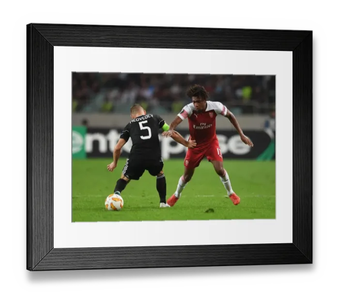 Framed Print : Arsenal's Alex Iwobi Clashes with Qarabag's Maksim Medvedev in Europa League Match