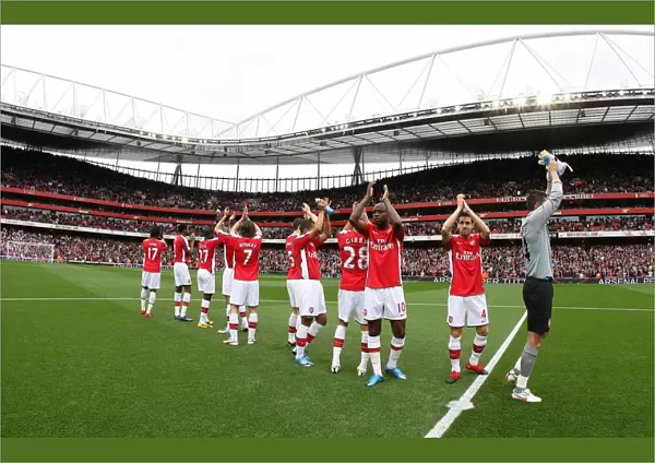 The Arsenal team clap the fans before the match