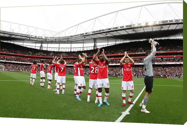 The Arsenal team clap the fans before the match