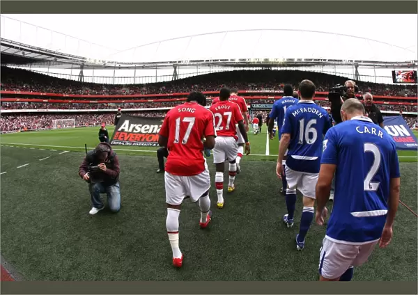 The Arsenal and Everton players walk out onto the picth