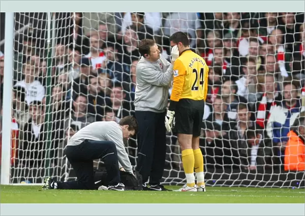 Arsenal goalkeeper Vito Mannone it treated by physio Colin Lewin