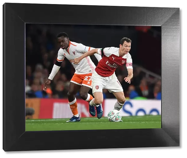 Arsenal's Lichtsteiner Clashes with Blackpool's Bola in Carabao Cup Showdown