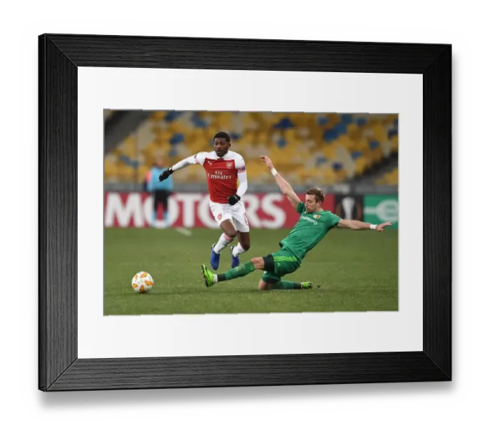Framed Print : Arsenal's Ainsley Maitland-Niles Faces Off Against Vorskla Poltava's Lurii Kolomoets in Europa League Clash