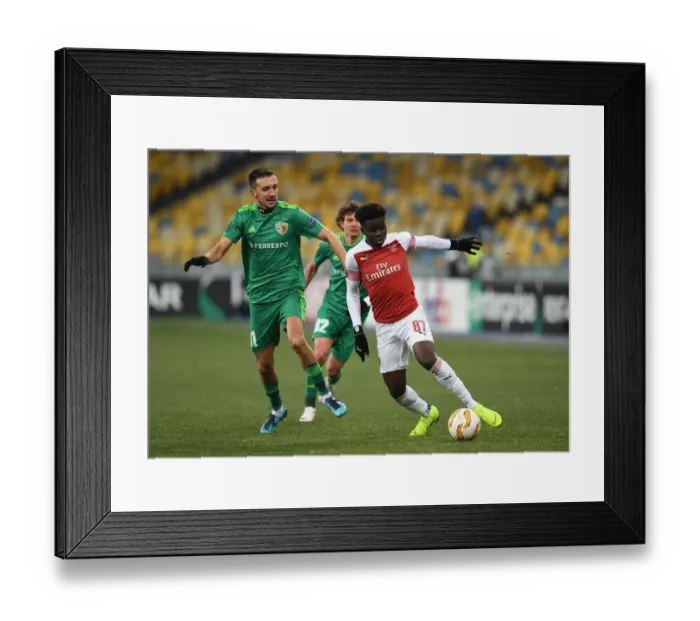 Framed Print : Arsenal's Bukayo Saka Clashes with Vyacheslav Sharpar of Vorskla in Europa League Match