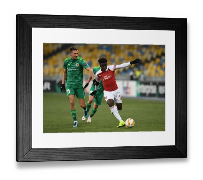 Framed Print : Bukayo Saka vs. Vyacheslav Sharpar: Arsenal's Rising Star Faces Off Against Vorskla Defender in Europa League Clash Framed Print : Bukayo Saka vs. Vyacheslav Sharpar: Arsenal's Rising Star Faces Off Against Vorskla Defender in Europa League Clash