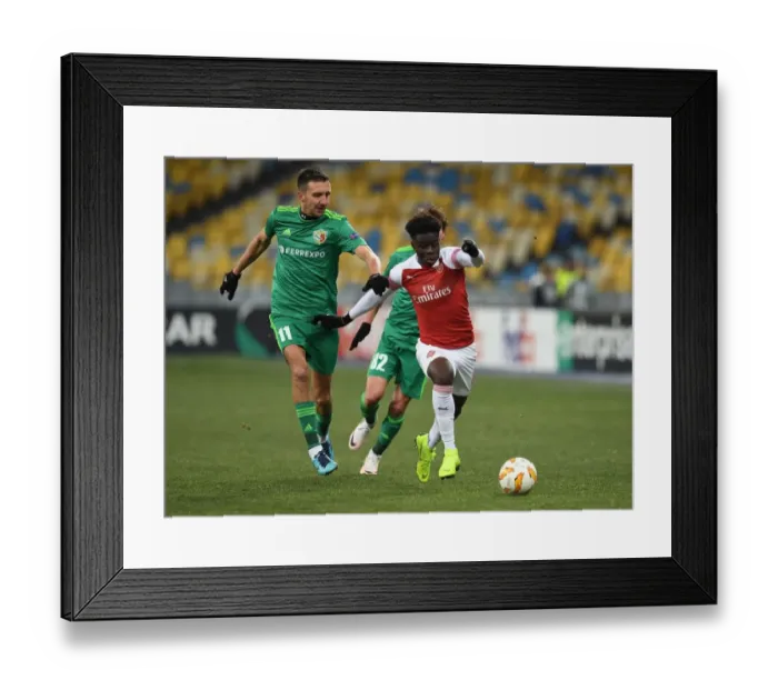 Framed Print : Arsenal's Bukayo Saka Clashes with Vyacheslav Sharpar in Europa League Showdown