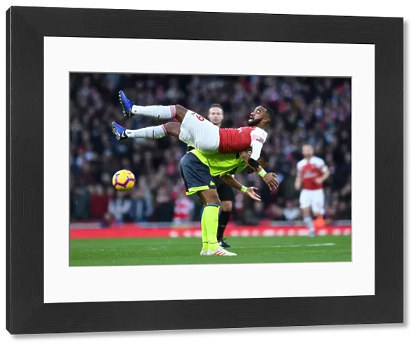 Arsenal's Lacazette Tangles with Huddersfield's Jorgensen in Premier League Clash