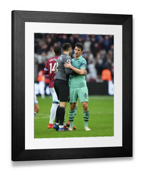 Framed Print : Former Arsenal Stars Koscielny and Fabianski Reunite: A Heartwarming Embrace on the Field Framed Print : Former Arsenal Stars Koscielny and Fabianski Reunite: A Heartwarming Embrace on the Field