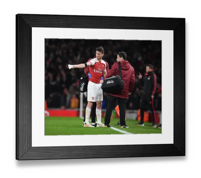 Framed Print : Arsenal's Koscielny Receives Medical Treatment from Doctor O'Driscoll during Arsenal vs Manchester United FA Cup Match