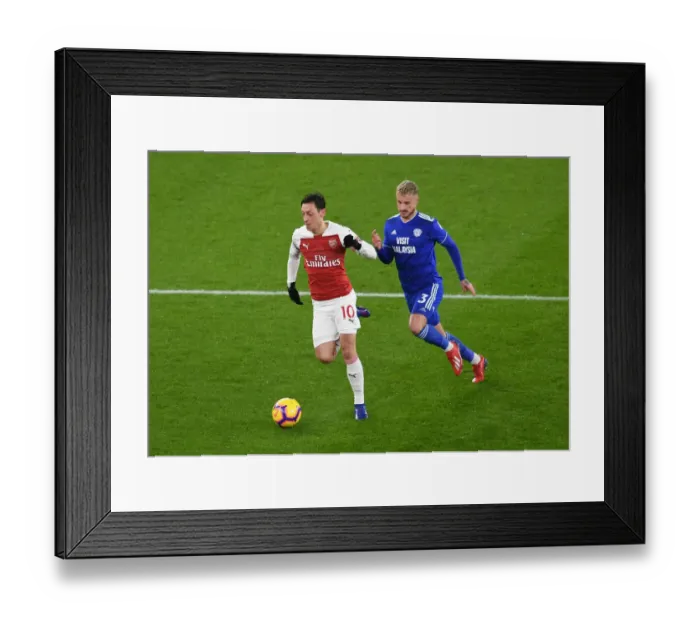 Framed Print : Arsenal's Mesut Ozil Clashes with Cardiff's Joe Bennett in Premier League Showdown