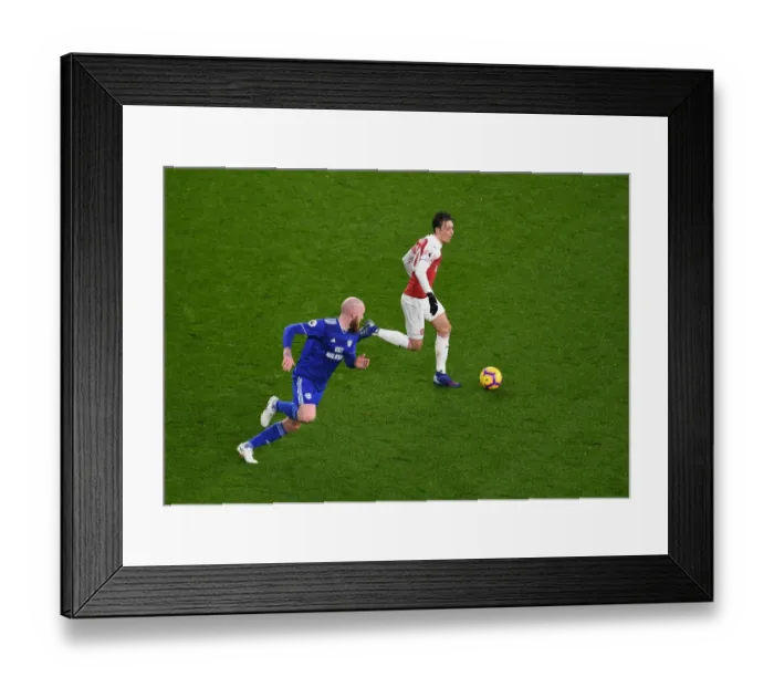 Framed Print : Arsenal's Ozil Clashes with Cardiff's Gunnarsson in Premier League Showdown