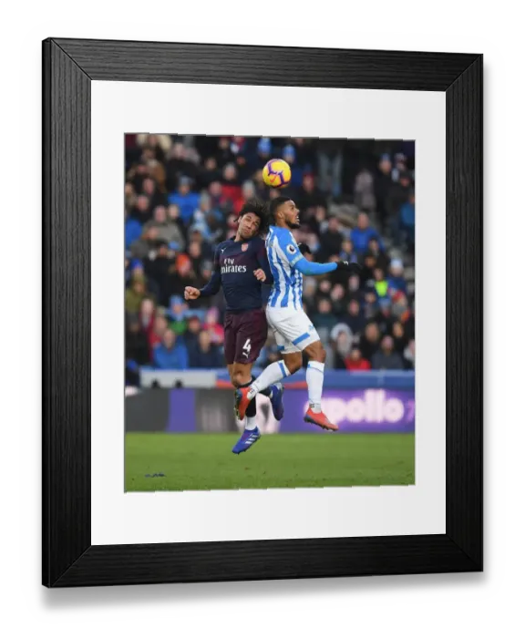 Framed Print : Arsenal's Mo Elneny Faces Off Against Huddersfield's Elias Kachunga in Premier League Clash