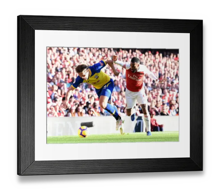 Framed Print : Arsenal's Lacazette Clashes with Southampton's Vestergaard in Premier League Showdown