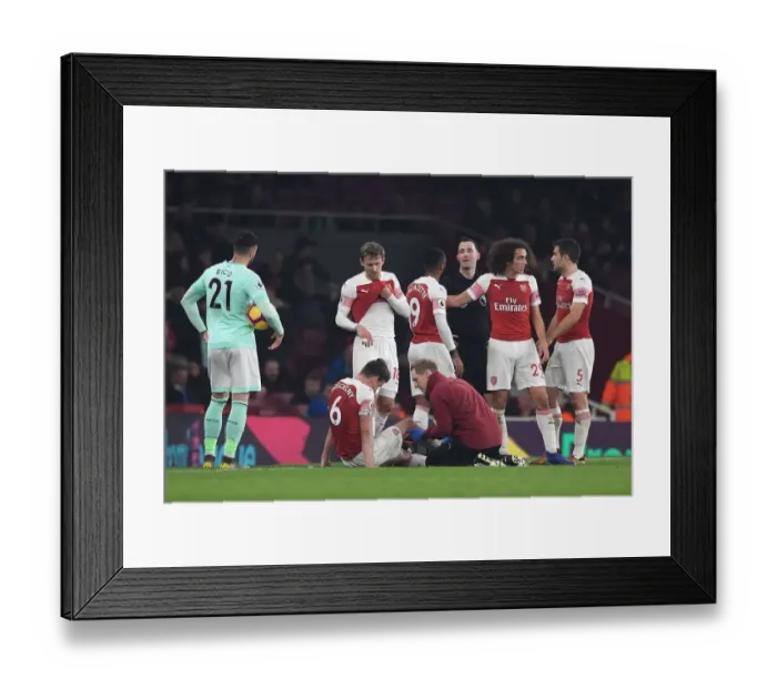 Framed Print : Arsenal's Koscielny Receives Treatment from Physio Jordan Reece during Arsenal v Bournemouth Match