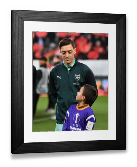 Framed Print : Mesut Ozil's Welcome: Arsenal Players Escorted at Stade Rennais, UEFA Europa League Round of 16 (First Leg)