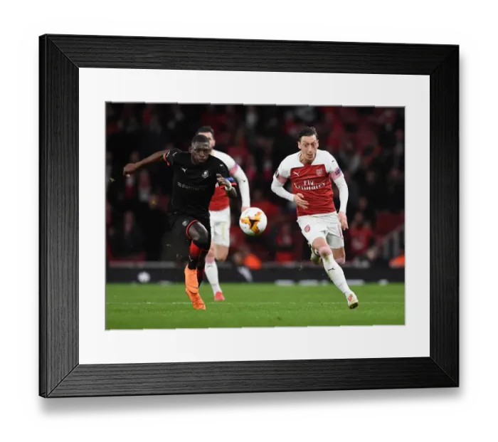 Framed Print : Arsenal vs Stade Rennais: Mesut Ozil Clashes with Hamari Traore in UEFA Europa League Showdown
