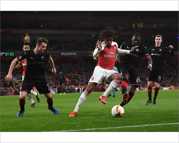 Arsenal's Alex Iwobi Clashes with Hamari Traore and Damien Da Silva of Stade Rennais in Europa League Showdown