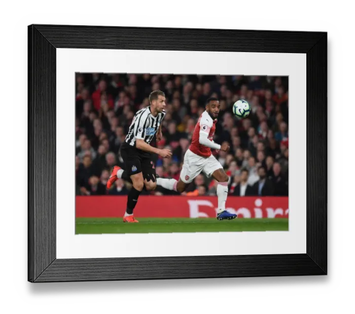 Framed Print : Arsenal's Alex Lacazette Faces Off Against Newcastle's Florian Lejeune in Premier League Clash