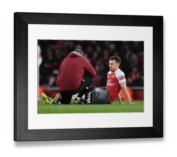 Framed Print : Aaron Ramsey (Arsenal) is treated for an injury