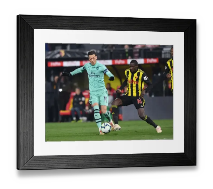 Framed Print : Mesut Ozil vs Abdoulaye Doucoure: A Premier League Showdown at Vicarage Road