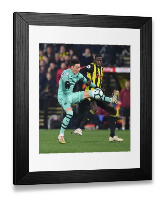 Framed Print : Mesut Ozil vs Abdoulaye Doucoure: A Premier League Showdown at Vicarage Road Framed Print : Mesut Ozil vs Abdoulaye Doucoure: A Premier League Showdown at Vicarage Road