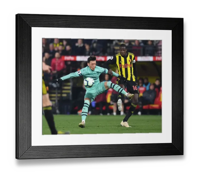 Framed Print : Mesut Ozil vs Abdoulaye Doucoure: A Premier League Battle of Skills and Strength Framed Print : Mesut Ozil vs Abdoulaye Doucoure: A Premier League Battle of Skills and Strength
