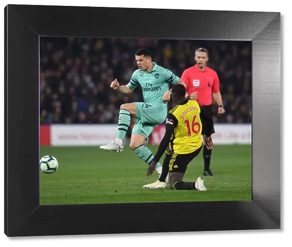 Clash at Vicarage Road: Xhaka vs. Doucoure in the Premier League Battle between Watford and Arsenal