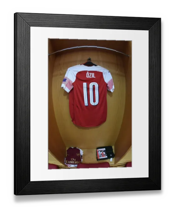 Framed Print : Arsenal's Empty Changing Room: Mesut Ozil's Absence in the UEFA Europa League Semi-Final vs Valencia