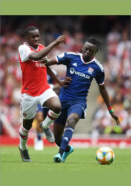 Arsenal's Eddie Nketiah Outmaneuvers Lyon's Bertrand Traore in Emirates Cup Clash