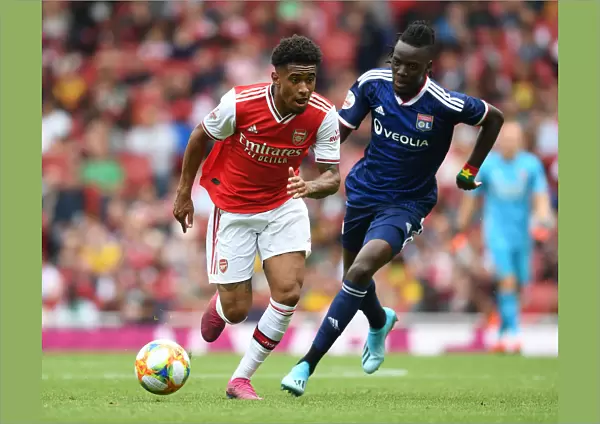 Arsenal's Reiss Nelson Outmaneuvers Olympique Lyonnais Bertrand Traore at Emirates Cup