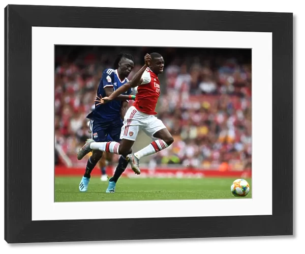 Arsenal's Eddie Nketiah Outmaneuvers Olympique Lyonnais Bertrand Traore during the 2019-20 Emirates Cup Match