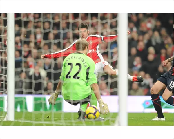 Cesc Fabregas shoots past Bolton goalkeeper Jussi Jskelainen to score the 2nd Arsenal goal