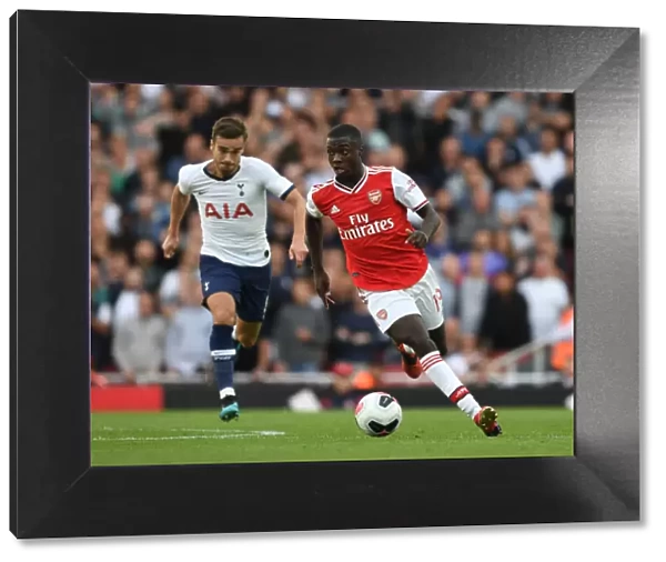 Arsenal's Nicolas Pepe Outmaneuvers Tottenham's Harry Winks in the 2019-20 Premier League Clash