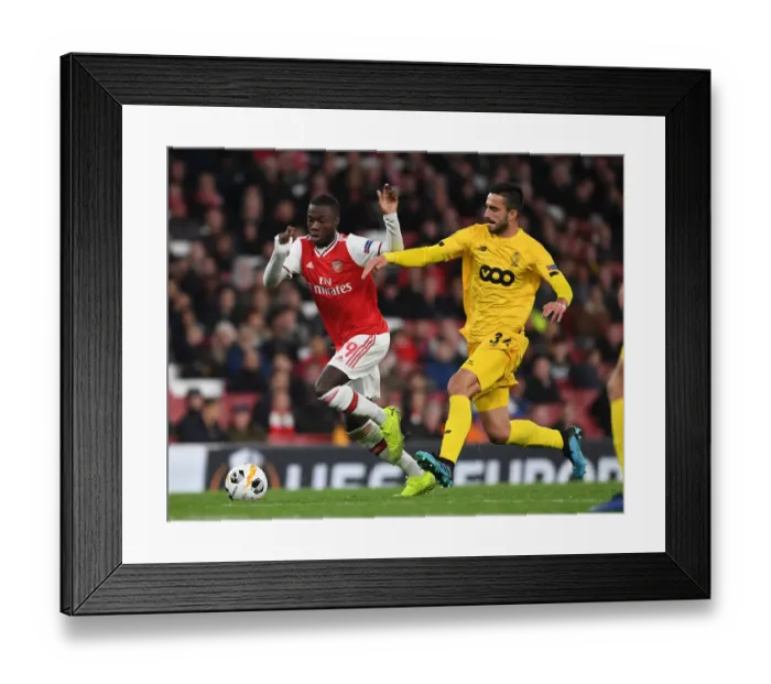 Framed Print : Arsenal's Nicolas Pepe Outmaneuvers Standard Liege's Kostas Laifis in UEFA Europa League Clash Framed Print : Arsenal's Nicolas Pepe Outmaneuvers Standard Liege's Kostas Laifis in UEFA Europa League Clash