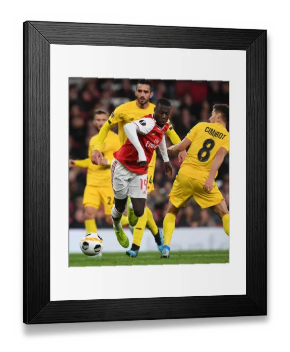 Framed Print : Arsenal's Nicolas Pepe Clashes with Standard Liege's Gojko Cimirot in Europa League Match