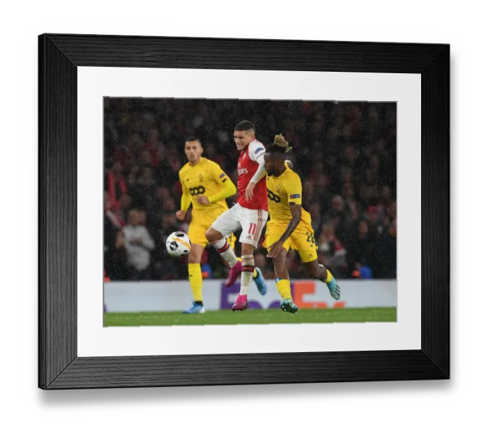 Framed Print : Arsenal's Lucas Torreira Overpowers Standard Liege's Samuel Bastien in Europa League Clash Framed Print : Arsenal's Lucas Torreira Overpowers Standard Liege's Samuel Bastien in Europa League Clash