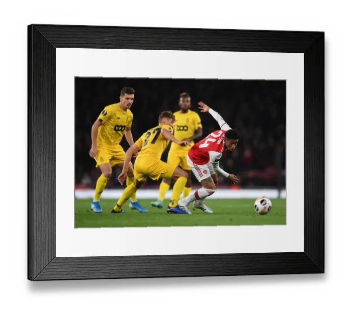 Framed Print : Arsenal's Reiss Nelson Faces Off Against Standard Liege's Mergim Vojvoda in UEFA Europa League Clash
