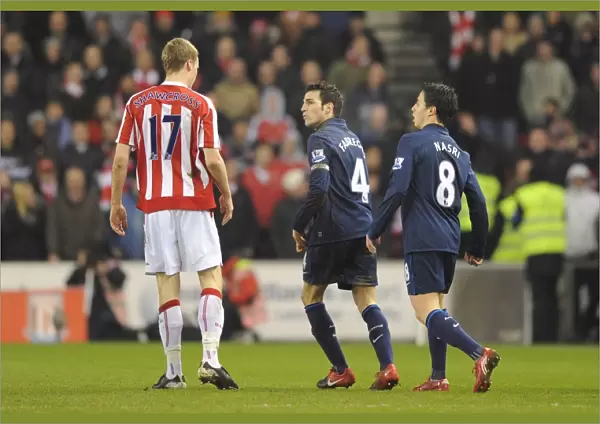 Cesc Fabregas and Samir Nasri (Arsenal) clash with Ryan Shawcross (Stoke)
