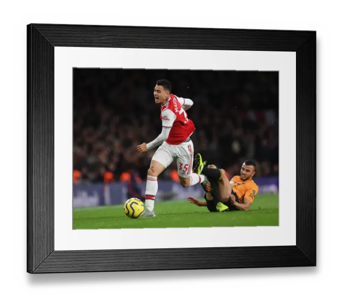 Framed Print : Martinelli Foul: Arsenal's Star Forward Halted by Saiss in Arsenal vs. Wolverhampton Clash (2019-20)