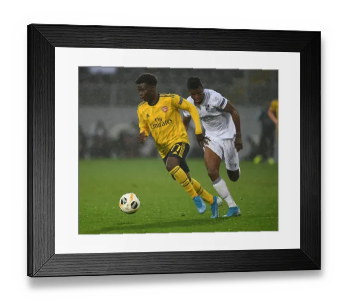 Framed Print : Arsenal's Bukayo Saka Outmaneuvers Vitoria Guimaraes Mikel Agu in UEFA Europa League Clash Framed Print : Arsenal's Bukayo Saka Outmaneuvers Vitoria Guimaraes Mikel Agu in UEFA Europa League Clash