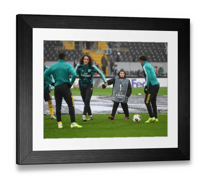 Framed Print : Arsenal Players Engage in Pre-Match Playtime with Ballboy Before Vitoria Guimaraes Clash