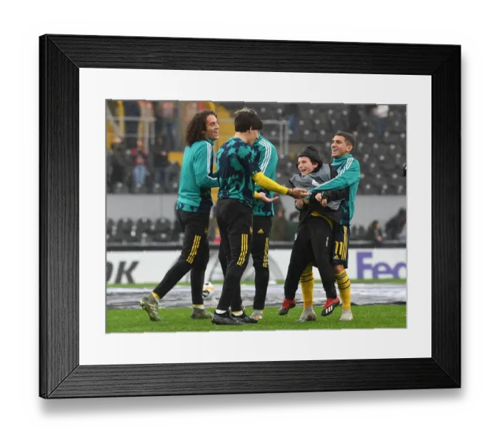 Framed Print : Arsenal Players Engage Local Ballboy in Warm-Up before Vitoria SC Clash in Europa League
