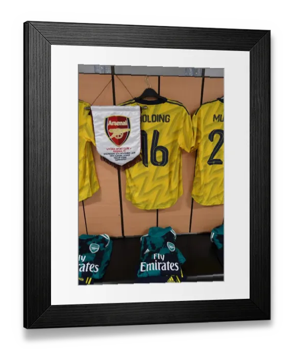 Framed Print : Arsenal's Rob Holding Displays Europa League Pennant Before Vitoria Guimaraes Clash Framed Print : Arsenal's Rob Holding Displays Europa League Pennant Before Vitoria Guimaraes Clash