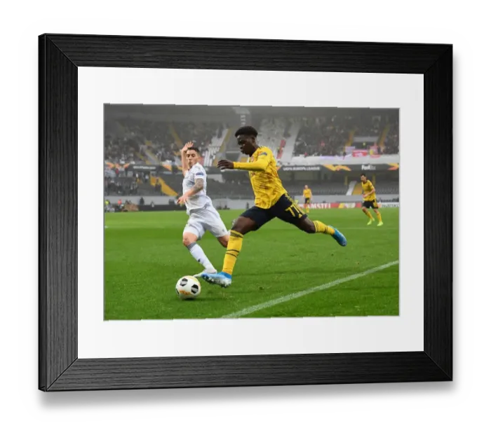 Framed Print : Bukayo Saka Faces Off Against Bruno Duarte: Vitoria Guimaraes vs. Arsenal, UEFA Europa League, 2019 Framed Print : Bukayo Saka Faces Off Against Bruno Duarte: Vitoria Guimaraes vs. Arsenal, UEFA Europa League, 2019