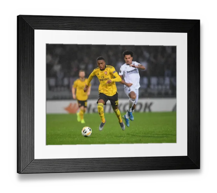 Framed Print : Arsenal's Joe Willock Goes Head-to-Head with Vitoria's Lucas Evangelista in Europa League Showdown