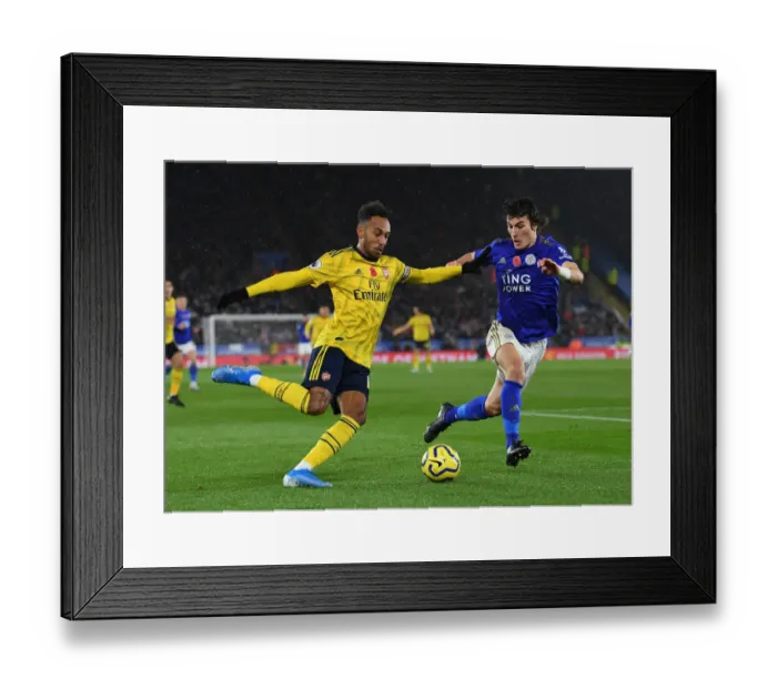 Framed Print : Aubameyang vs Soyuncu: Intense Heading Battle in Leicester City vs Arsenal FC, Premier League 2019-20