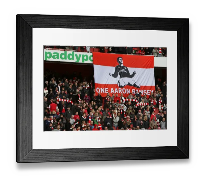 Framed Print : Arsenal fans have a banner supporting Aaron Ramsey who broke his leg in the previous match Framed Print : Arsenal fans have a banner supporting Aaron Ramsey who broke his leg in the previous match