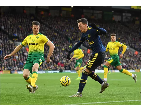 Mesut Ozil Evades Pressure from Christoph Zimmermann during Norwich City vs Arsenal Premier League Clash