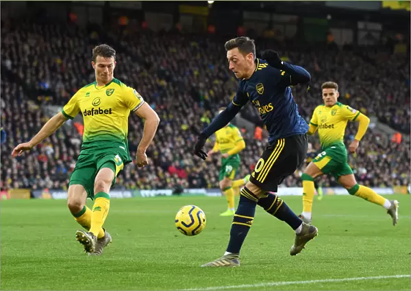 Mesut Ozil Evades Pressure from Christoph Zimmermann during Norwich City vs Arsenal Premier League Clash
